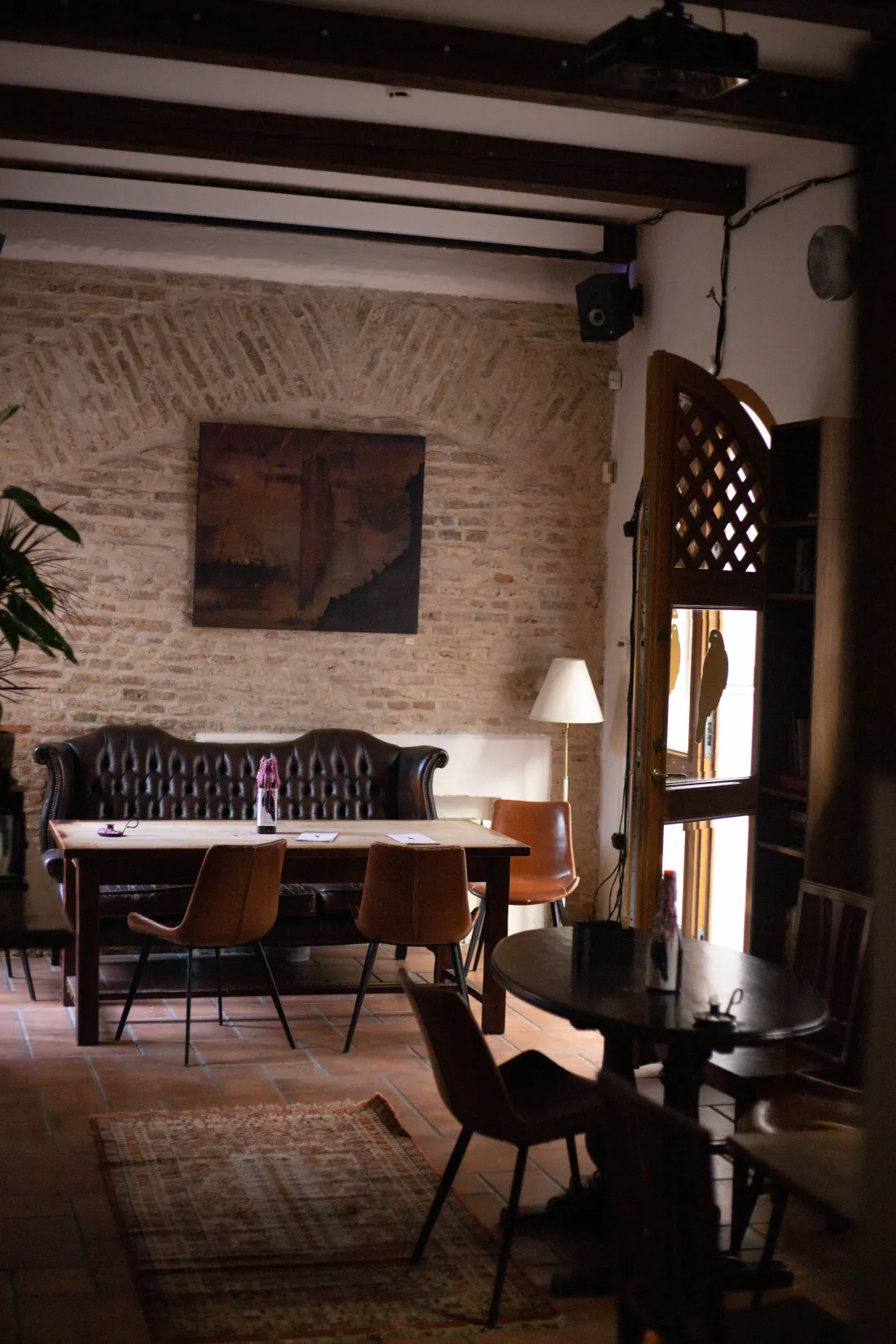 The room at Vanagai: exposed brick, a leather chesterfield, and warm amber light