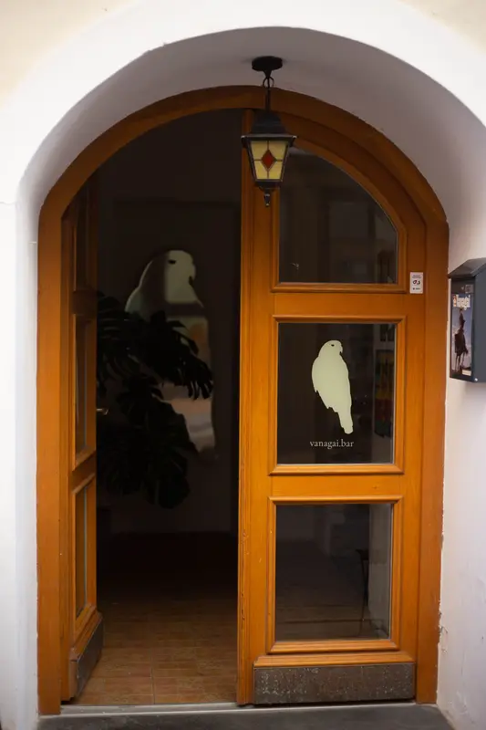 Arched wooden front door with the Vanagai hawk