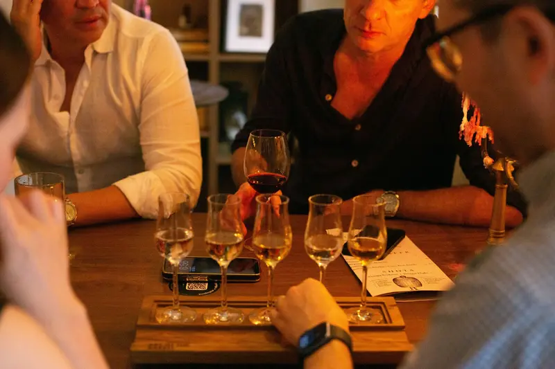 Guests around a table with glasses lined up on a wooden board